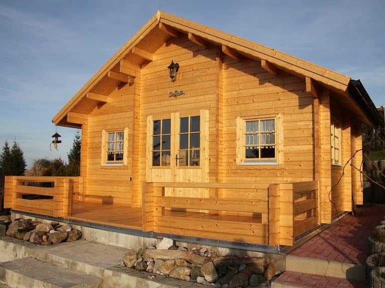 Eine kleine Blockhütte mit Veranda und Terrasse.