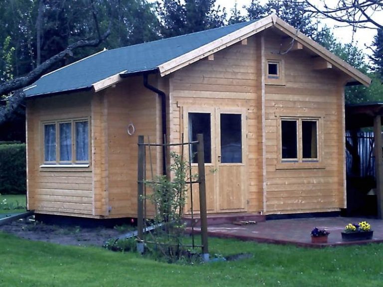 Eine kleine Holzhütte in einem Hof.