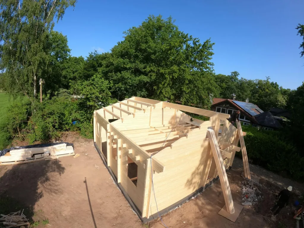 Zwei Handwerker bauen die Wände eines Blockhauses auf
